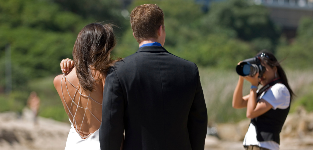 A photographer captures newlyweds at their beach wedding