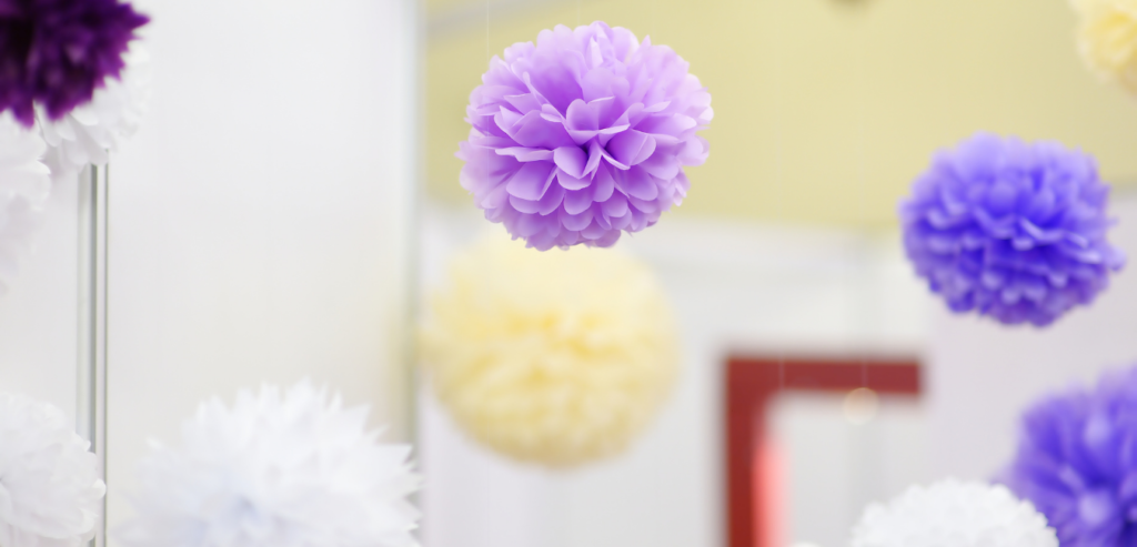 Hanging tissue poms decorate a wedding reception